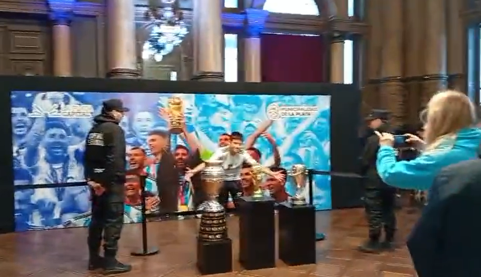 un joven tomandose fotos con la copa del mundo en el salon dorado del palacio municipal de La Plata